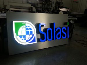 Picture of lighted sign with green and blue logo of world